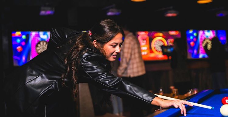 Woman playing Pool with AR Darts in background